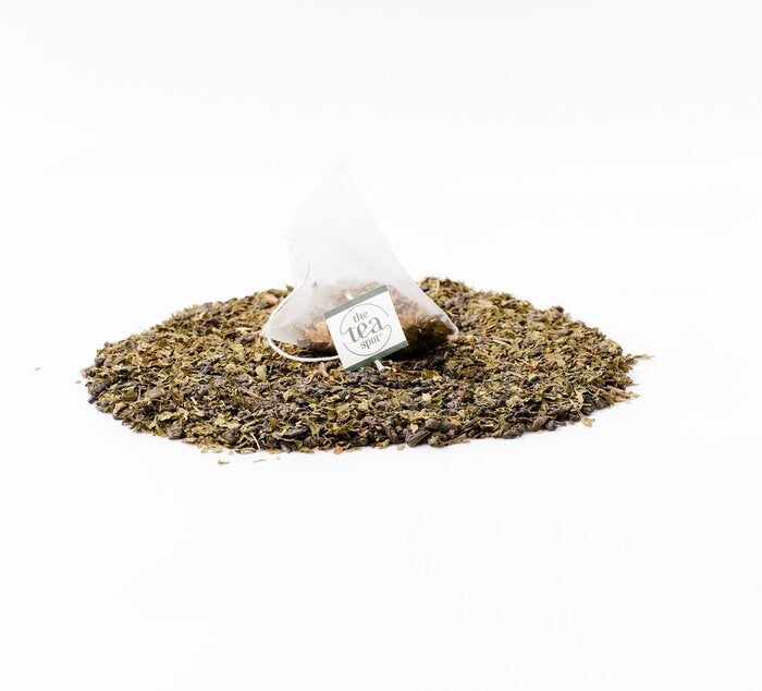 
                  
                    a tea bag filled with moroccan mint tea sits on top of loose leaf moroccan mint
                  
                