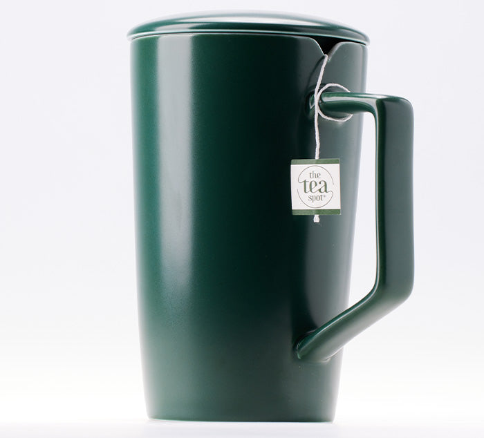
                  
                    a green ceramic tea mug with a notch for a tea bag that is wrapped around the handle
                  
                