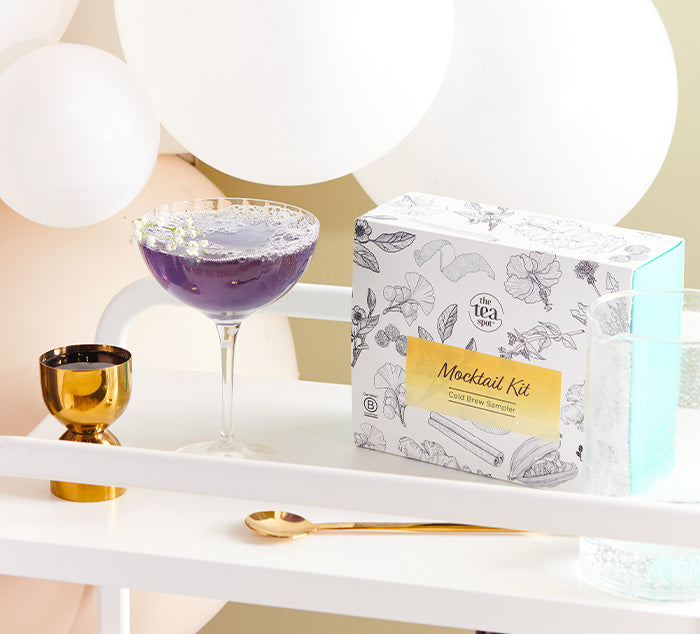 a mocktail sits on a bar cart with a box reading mocktail kit next to it