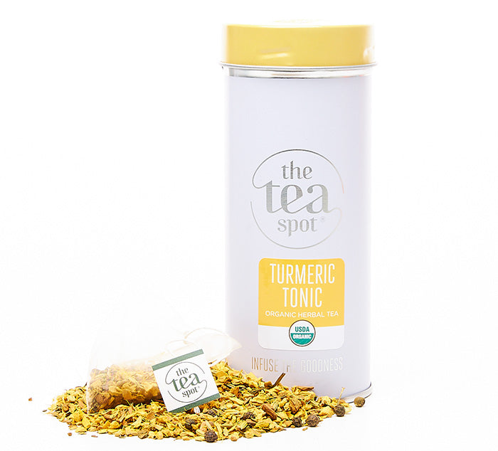 
                  
                    a tin of tea that reads turmeric tonic organic herbal tea sits behind loose leaf tea and a tea bag
                  
                