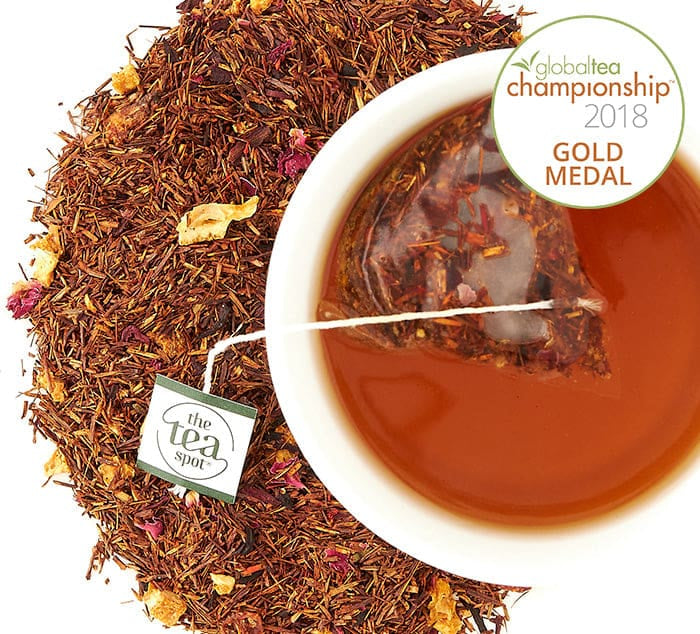 Blood Orange Smoothie tea bag Steeped in a tea mug surrounded by loose leaf tea