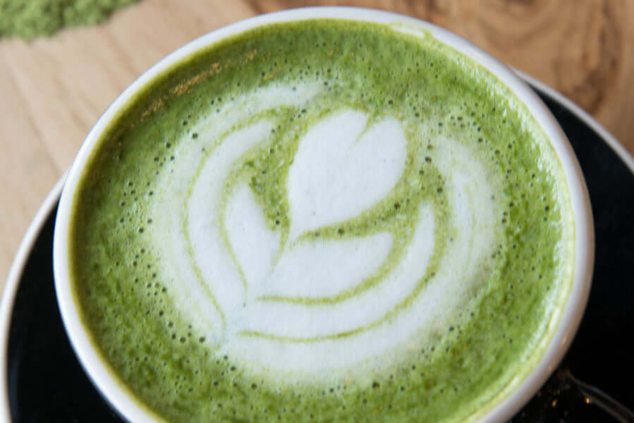 a matcha latte in a black cup