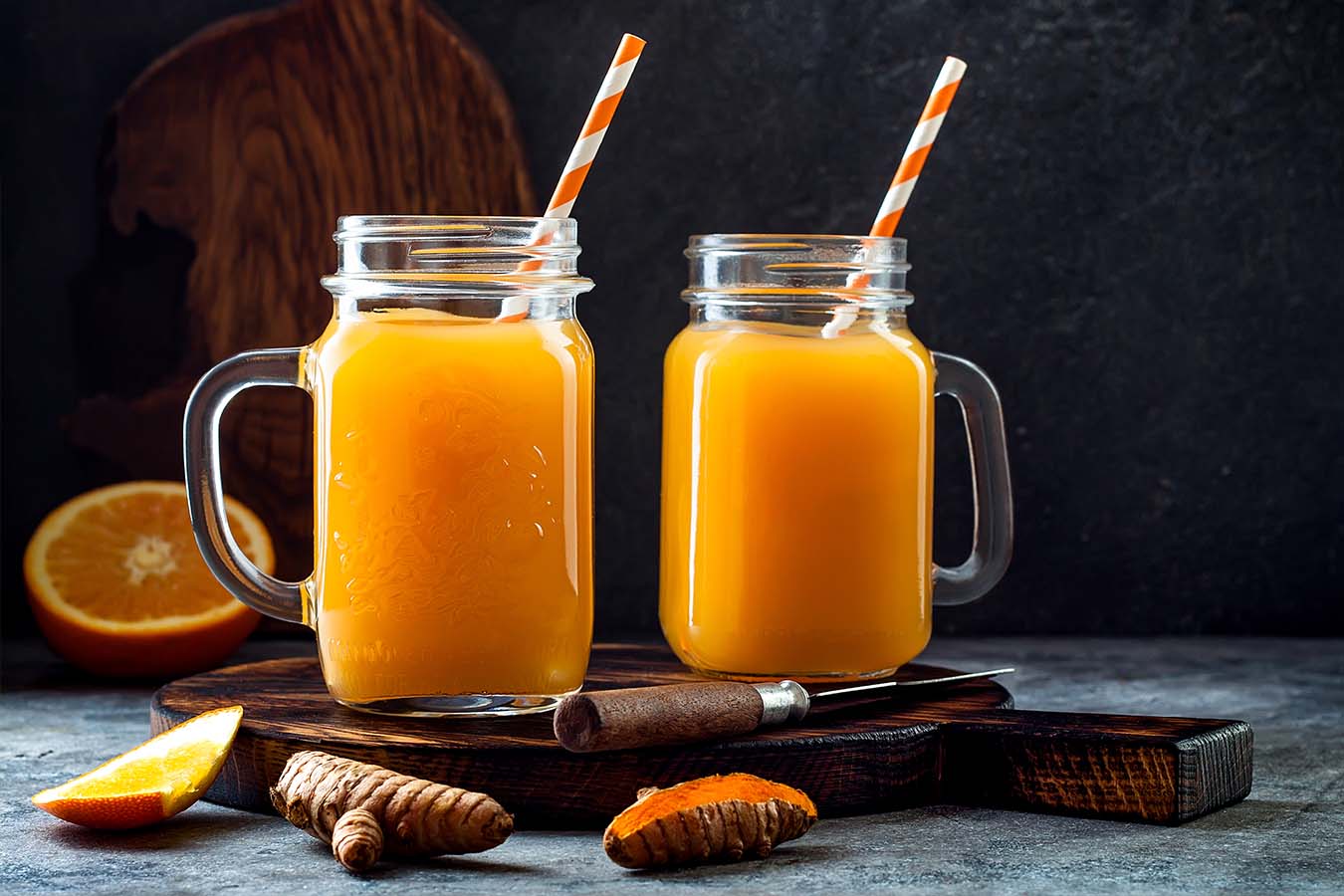 two glasses sit on a table with a turmeric tonic mocktail inside