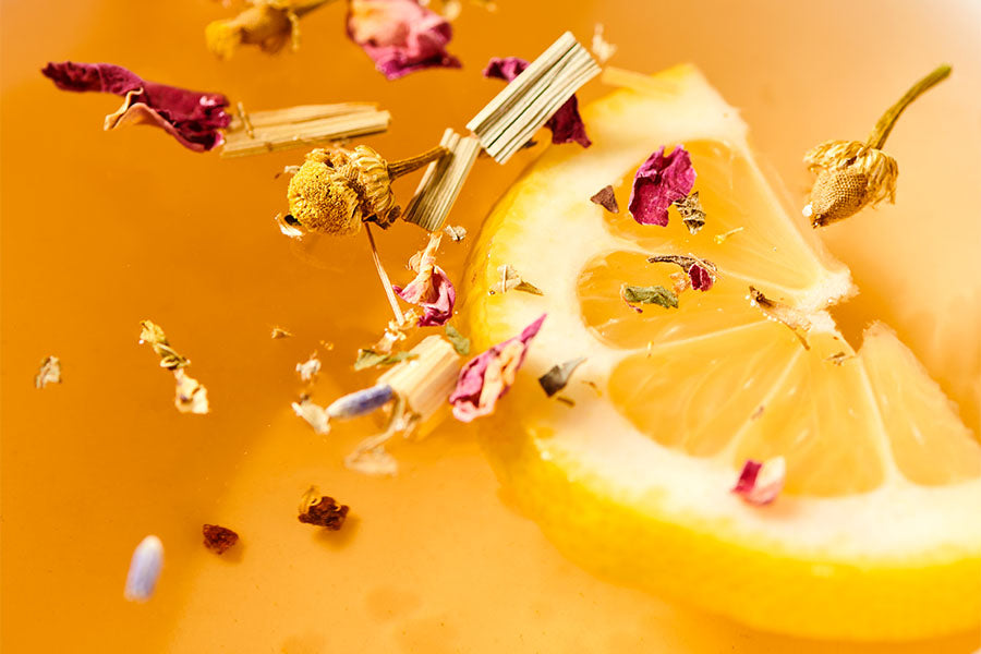 loose leaf tea floating in water with a lemon slice