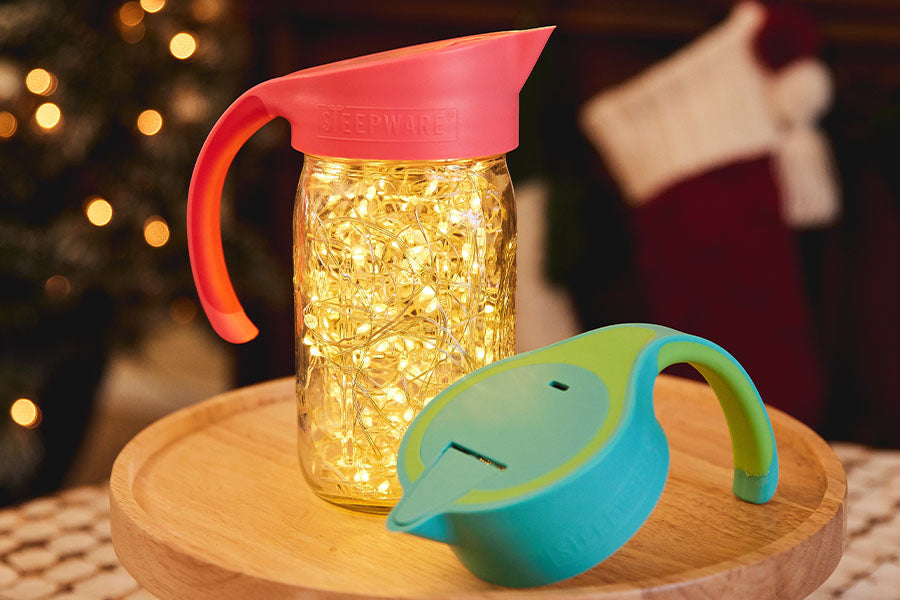 a tea filter that attaches to a mason jar is sitting on a table filled with christmas lights