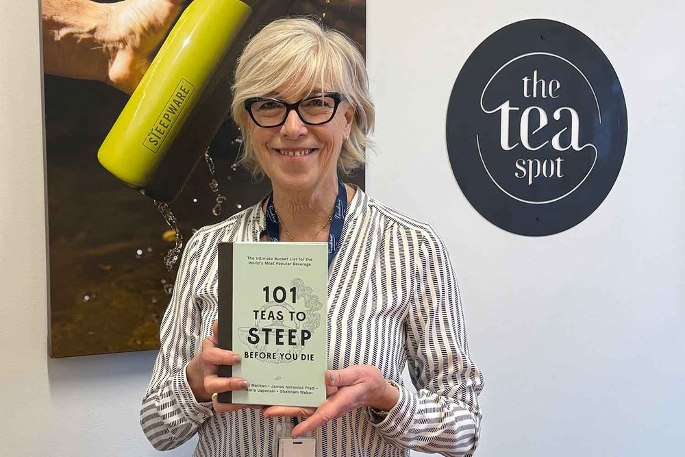 maria uspenski holds a copy of her book, 101 teas to steep before you die
