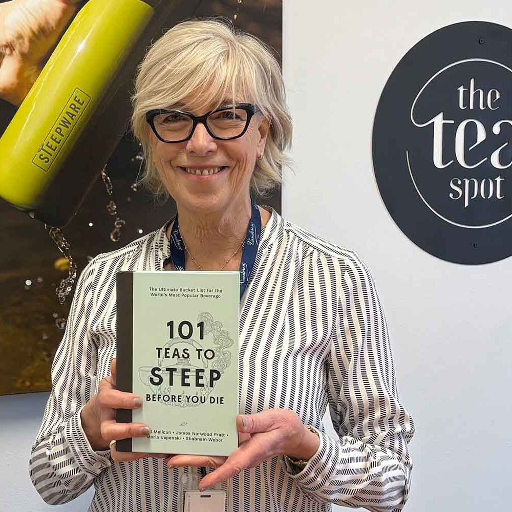 maria uspenski holds a copy of her book, 101 teas to steep before you die
