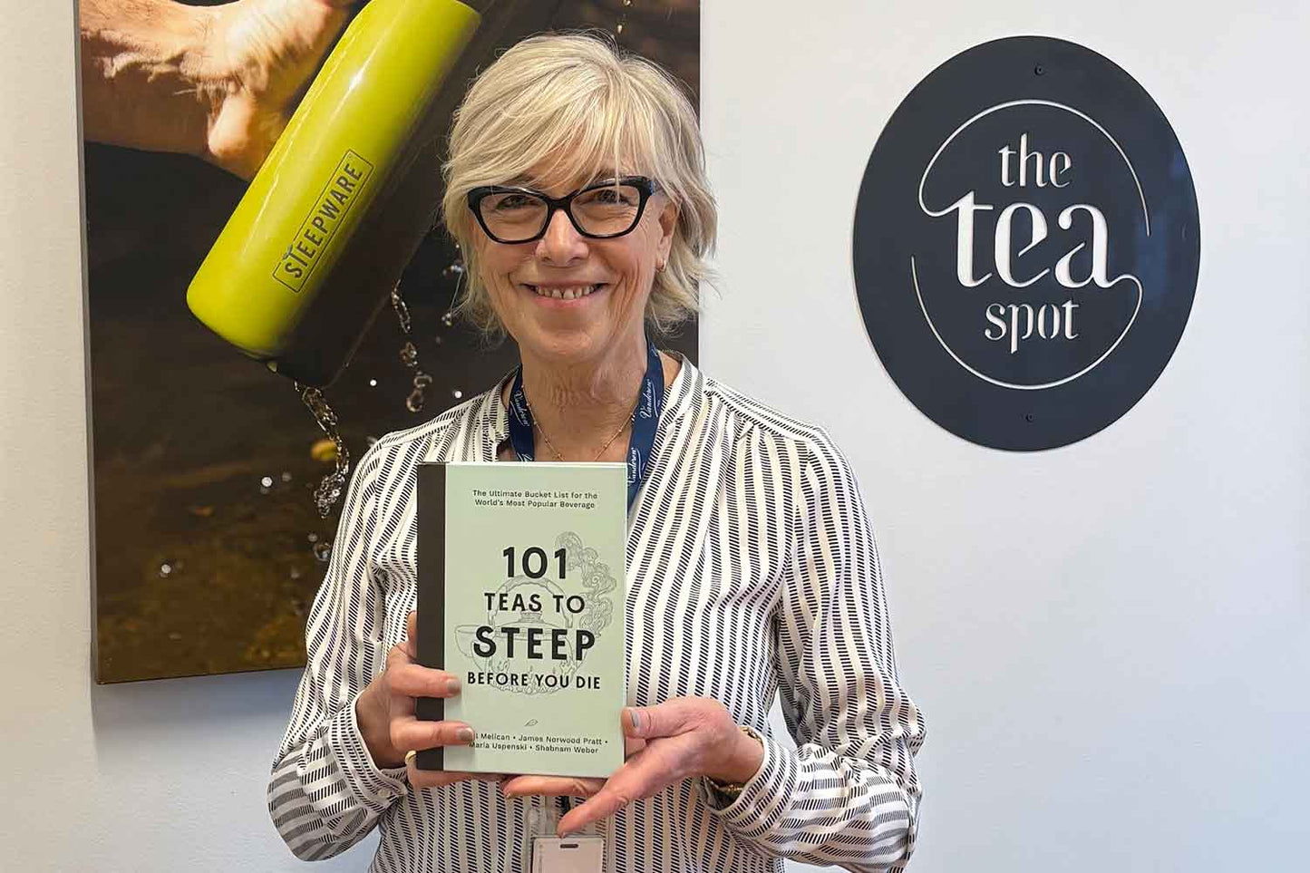 maria uspenski holds a copy of her book, 101 teas to steep before you die