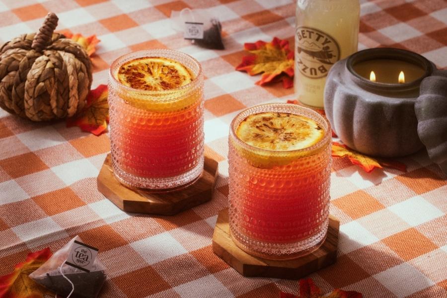 two tea mocktails sit on a table with fall decorations