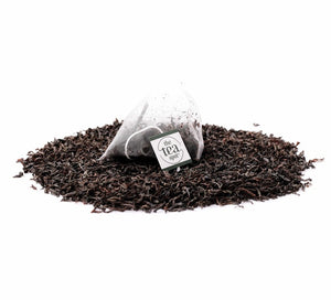 ceylon black tea in a tea bag sits on top of loose leaf tea