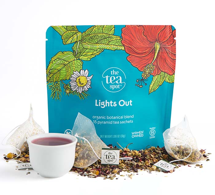 lights out organic tea bags sit on top of loose leaf tea in front of a teal bag reading lights out sleepy tea caffeine free tea