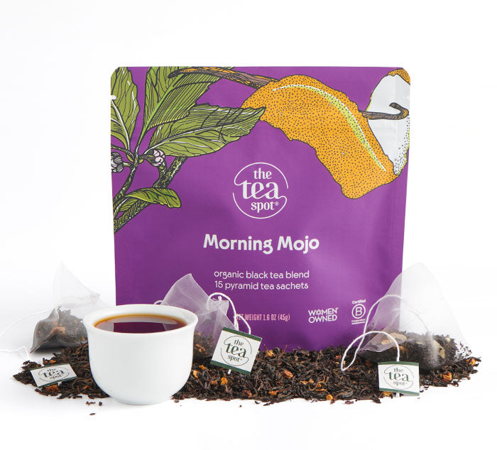 Morning Mojo Tea bags sit on top of loose leaf tea in front of bagged tea reading whole leaf black tea to support healthy digestion
