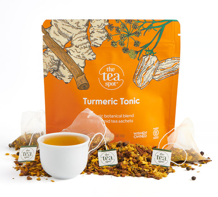 turmeric tonic tea bags sit on a pile of loose leaf tea in front of a bag that reads turmeric tonic a unique blend 