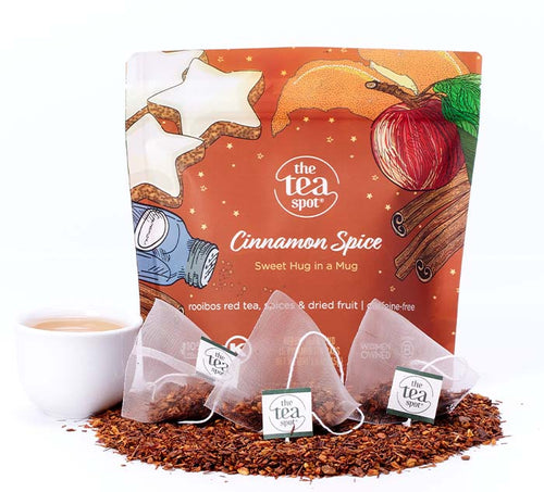 an orange bag says cinnamon spice sweet hug in a mug with tea bags and loose leaf tea in front of it