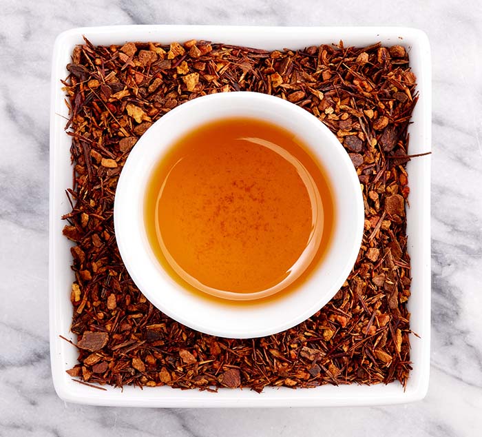 
                  
                    a cup of brewed cinnamon spice tea sits in a dish with loose leaf cinnamon tea in it
                  
                