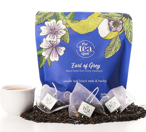 a blue bag that reads earl of grey, next level earl grey tradition sits behind loose leaf tea and tea bags of earl grey tea