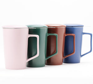 a set of four ceramic mugs, green, pink, brown, and blue in a line