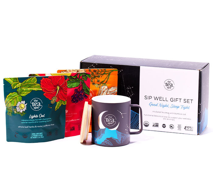 a box reading good night sleep tight gift set sits next to three bags of tea, in front of them sits a ceramic-lined stainless steel mug with a moon design