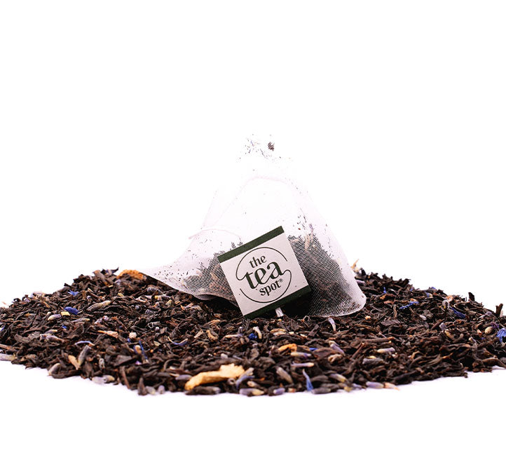 a tea bag with lady grey lady lavender tea in it sits on top of a pile of loose leaf lady lavender tea