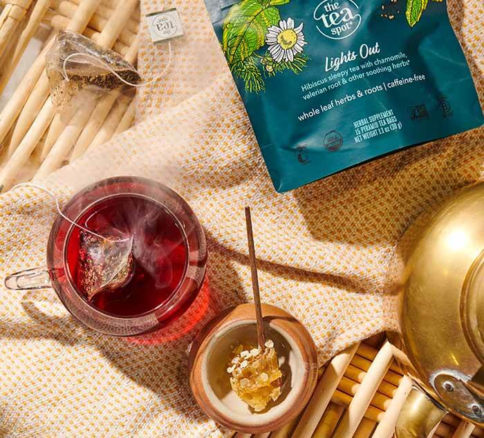 a bag reading lights out sits on a tray with brewed lights out sleepy tea in tea bags