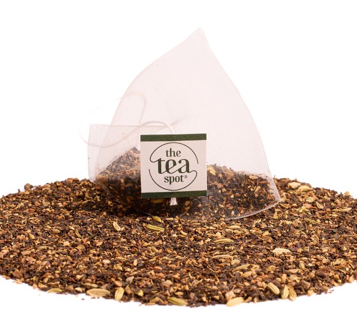 a tea bag filled with masala chai tea sits on top of a pile of loose leaf masala chai tea