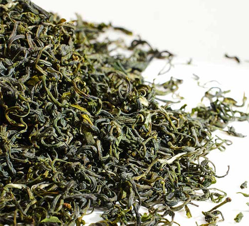 Close-up of pan long yin hao green tea leaves on a white background