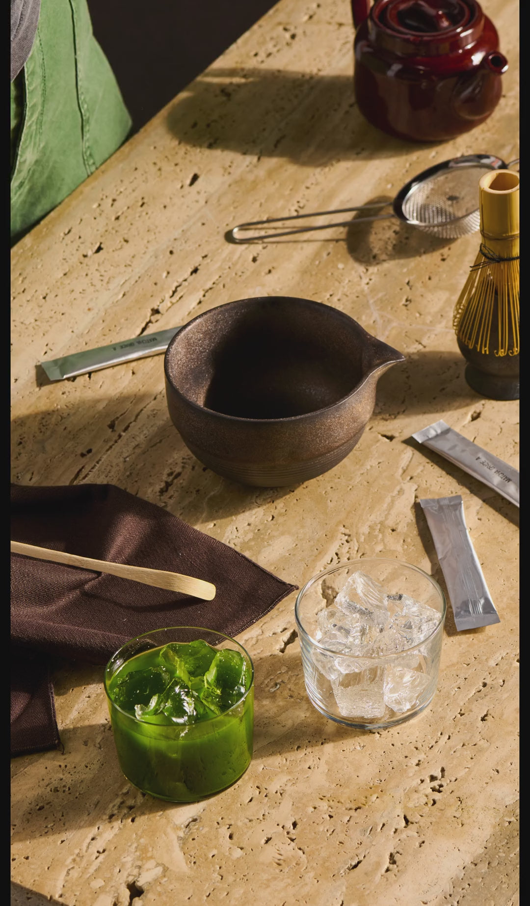 a person whisks matcha in a bowl and pours it into a glass