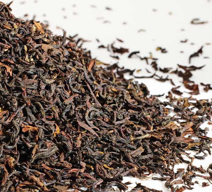 Close-up of puttabong darjeeling tea leaves on a white background