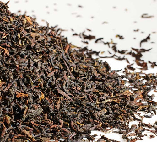 Close-up of puttabong darjeeling tea leaves on a white background