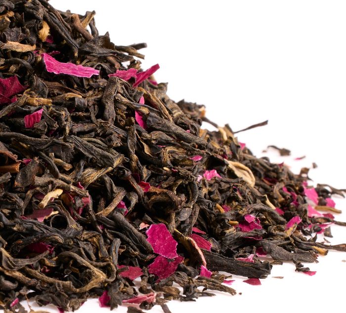 Black tea leaves with rose petals on a white background