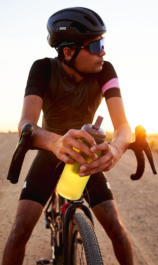 a man holds a tea water bottle on a bike