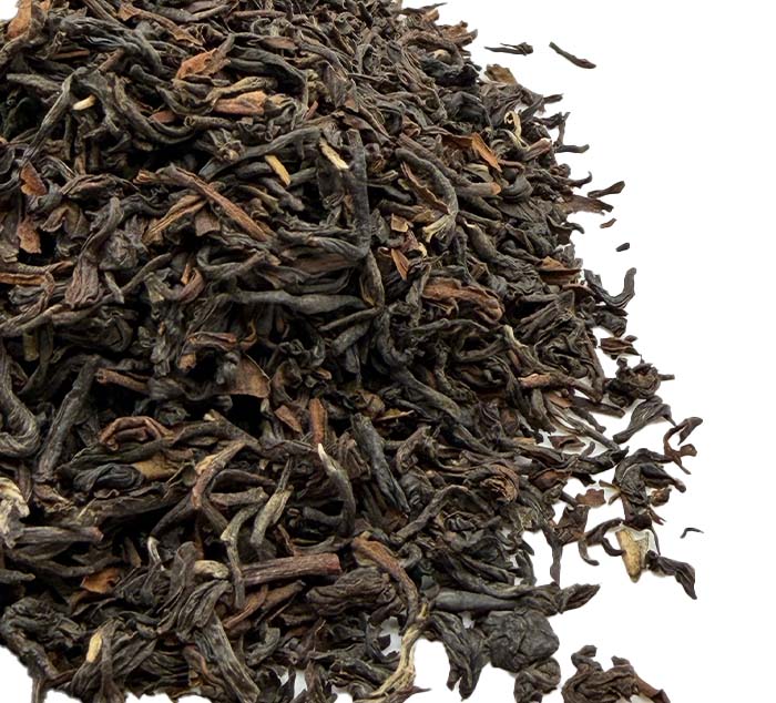 Close-up of dried black darjeeling tea leaves on a white background