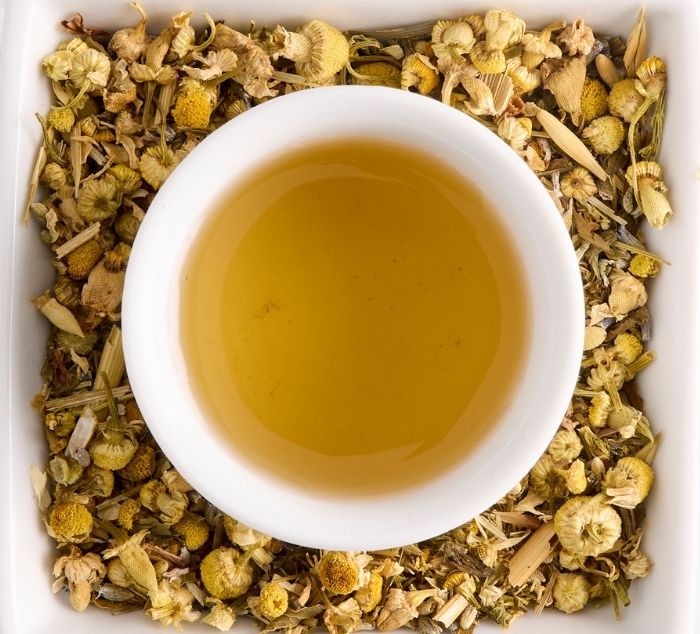 a brewed cup of sweet dreams tea sits on a bed of loose leaf tea