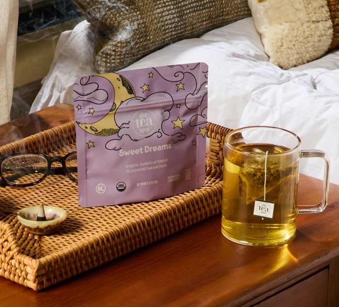 a package reading sweet dreams sits on a nightstand next to a brewed cup of sleep tea