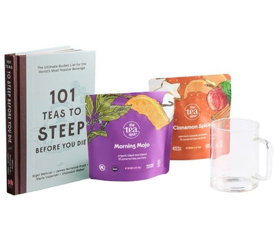 tea titled 101 teas to steep before you die sits next to two bags of tea and a glass tea mug