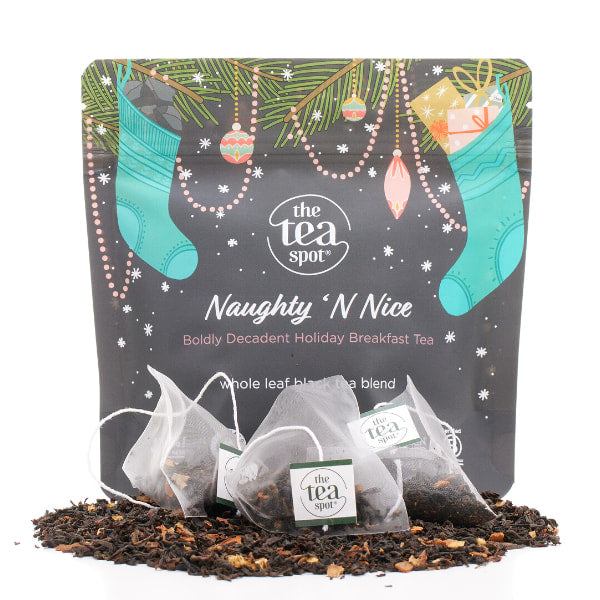 a pouch labeled naughty 'n nice stands behind tea bags and loose leaf tea for christmas