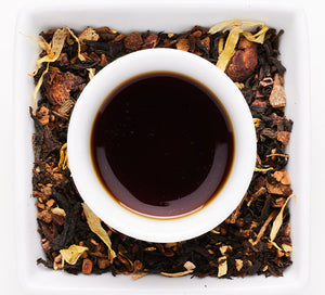 adobe sunrise, black tea with mushrooms is brewed in a cup surrounded by loose leaf tea