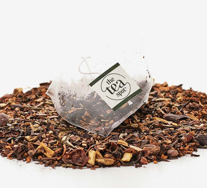 a tea bag sits on a pile of loose leaf black tea