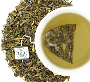 Boulder Blues tea bag Steeped in a tea cup with loose leaf tea leaves surrounding