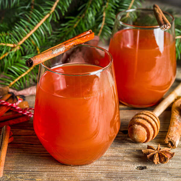 two glasses filled with tea mocktails sit on a table