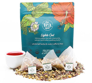 lights out organic tea bags sit on top of loose leaf tea in front of a teal bag reading lights out sleepy tea caffeine free tea