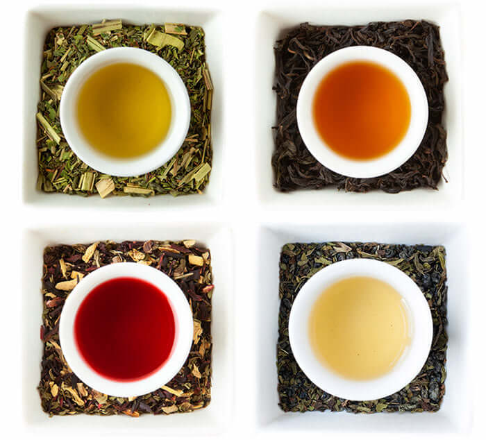 Array of four loose leaf teas with bowls, showcasing vibrant colors; part of The Tea Spot Sipping Club - Replenish collection.