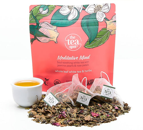 meditative mind tea bags sitting on a pile of loose leaf tea in front of a pink bag reading meditative mind 