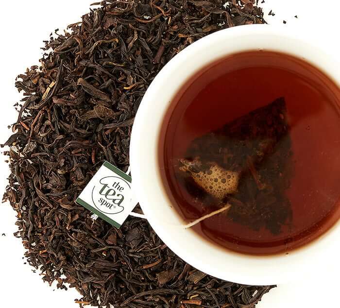 Cup of Organic Russian Caravan loose leaf tea with tea leaves, smoky blend, best breakfast tea.