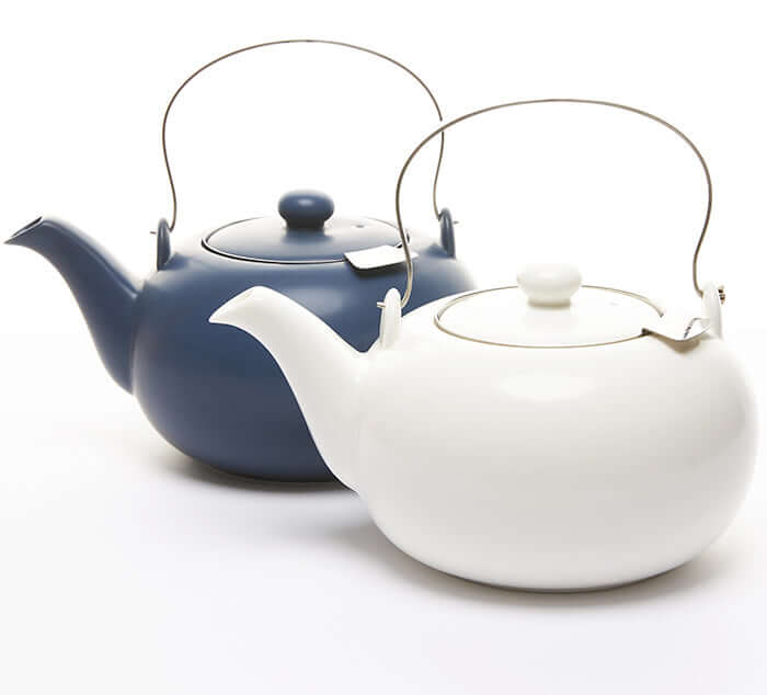 Two satin teapots, one navy and one white, perfect for brewing loose leaf tea, each with a handle and lid.
