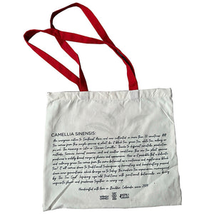 a white tote bag with text about camellia sinensis the tea plant